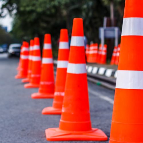 A line of orange traffic cones along a road