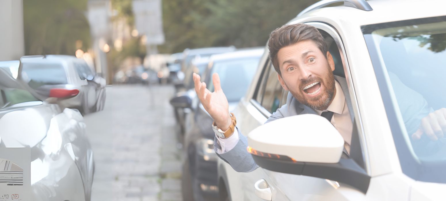 A driver leaning out of his car window in slow-moving traffic