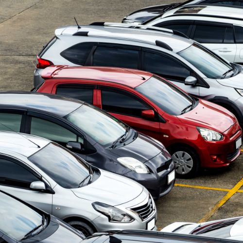 Rows of parked cars in silver, gray, and red